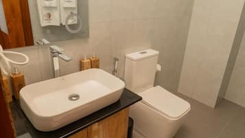 Ein Badezimmer mit einem weißen Waschbecken, einer Toilette und einem Spiegel über dem Waschbecken.
