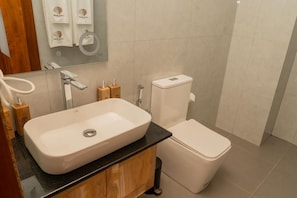 Ein Badezimmer mit einem weißen Waschbecken, einer Toilette und einem Spiegel über dem Waschbecken.