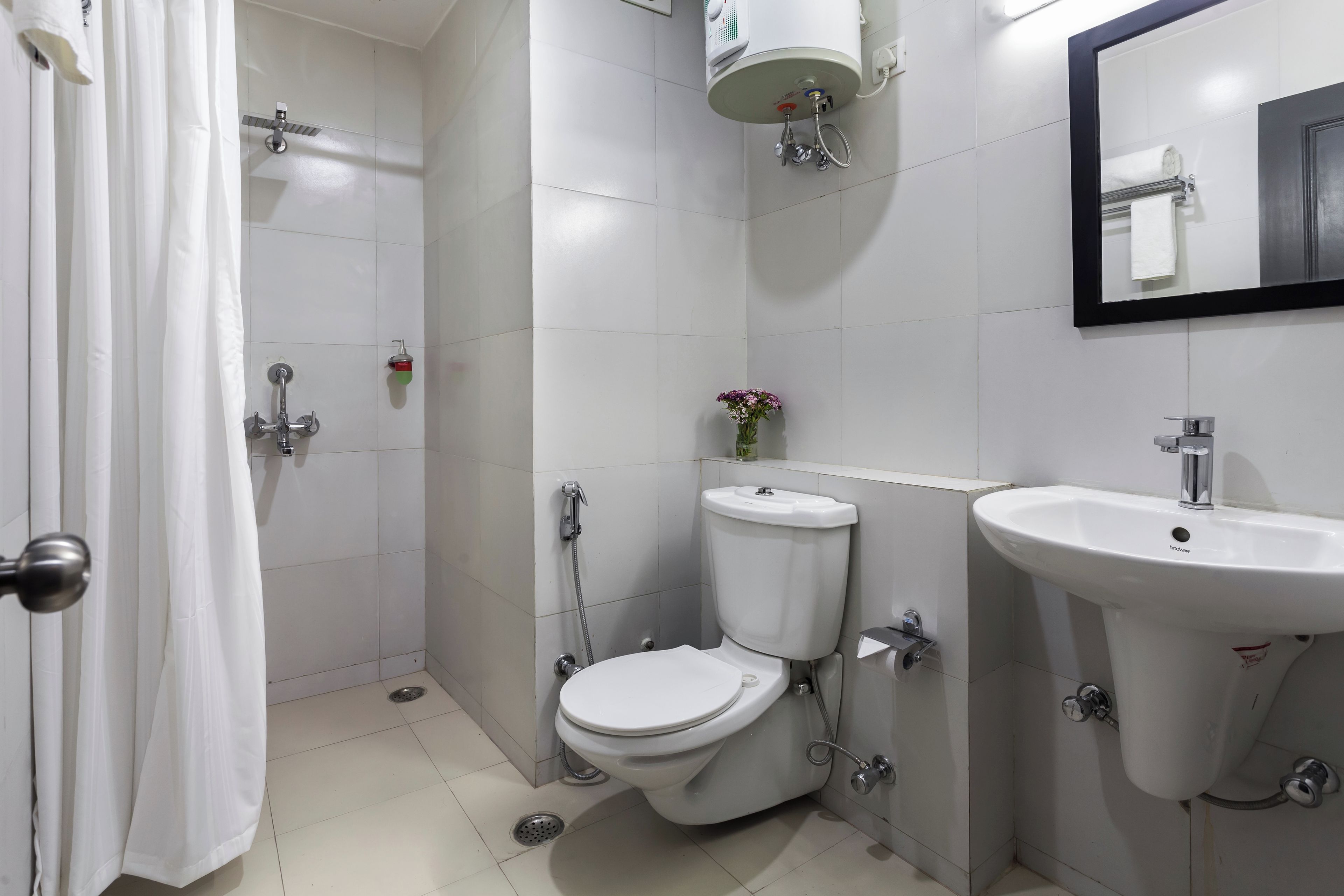 A bathroom with a toilet, bidet, sink, and shower.