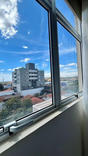 A window with a view of a multi-story building with a flat roof and several windows. - Apartment - Flat Belotto 01 __ 15 minutes from Confins Airport (Lagoa Santa)