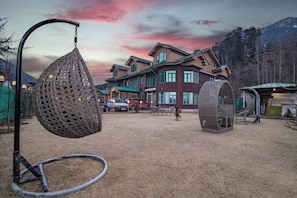 A residential area with a large house, a hanging chair, and a tire swing. - Hayat Residency pahalgam (Pahalgam)