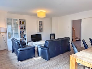 A modern living room with a sofa, a television, and a bookshelf. - My Glowe - DHH Right (Glowe)