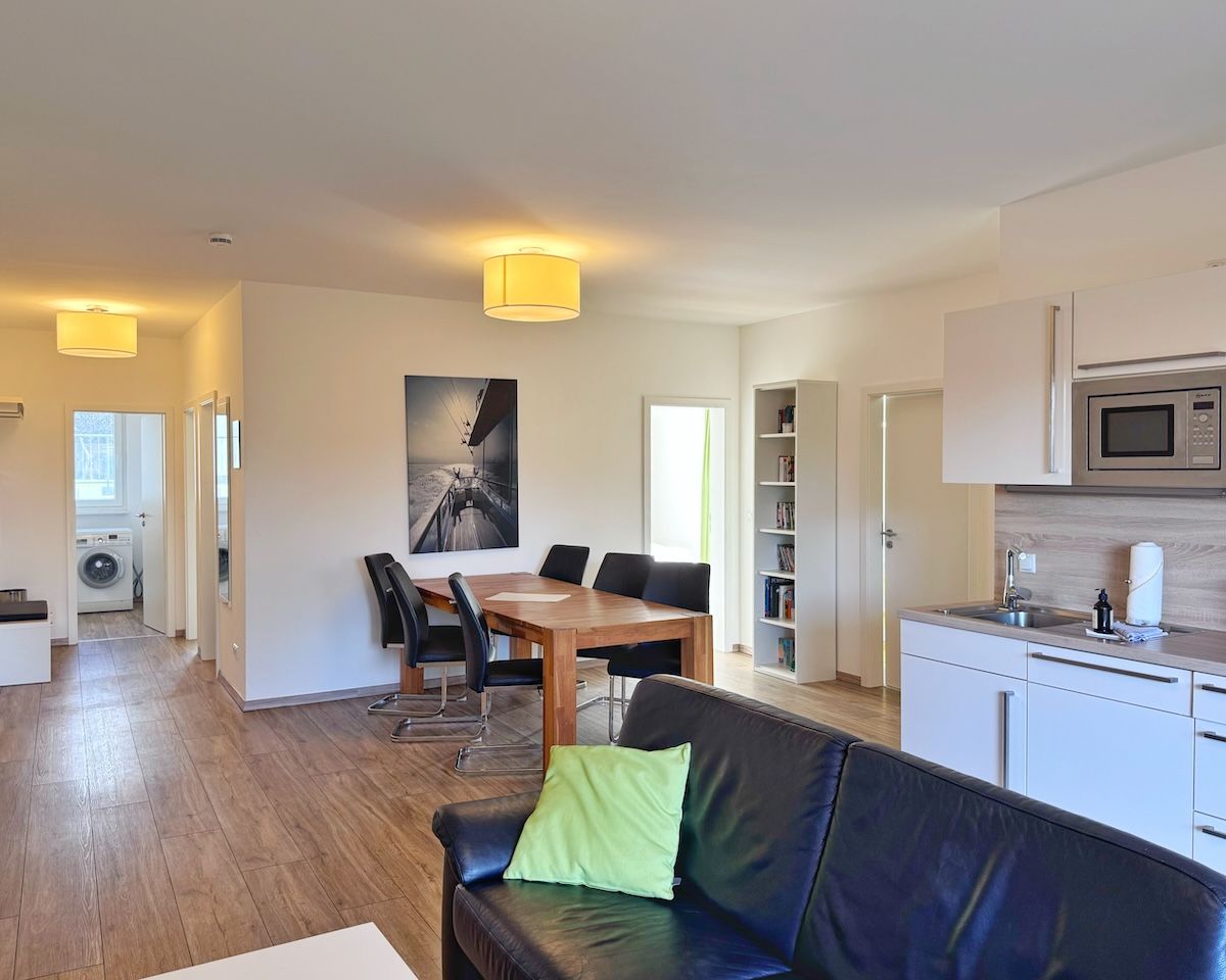 Un appartement moderne comprenant un coin repas, une cuisine et un espace de vie.