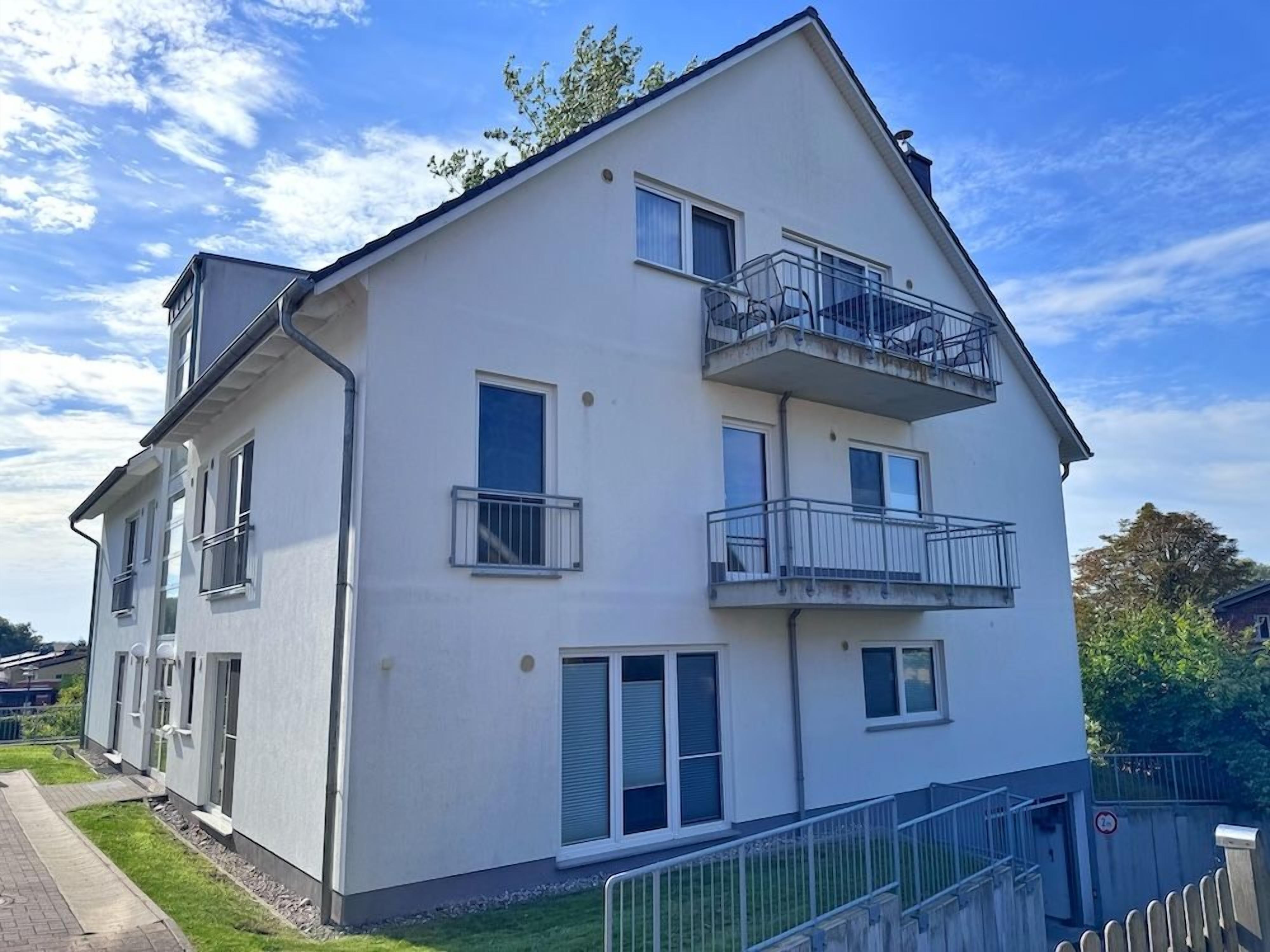 A two-story residential building with a balcony on the upper floor.