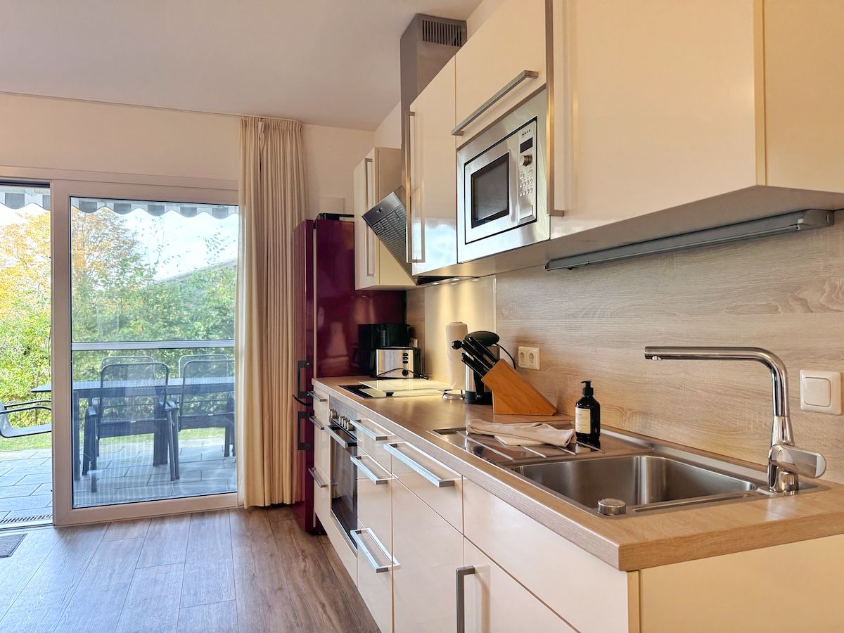 Eine moderne Küche mit integriertem Mikrowellenherd, Backofen und Spüle.