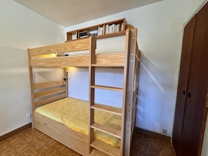 A bunk bed with a wooden frame and a shelf above the top bunk. - 50m from ski slopes, 7th floor, balcony, tv, ski locker, 53m², Vars (Vars)