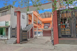 Um edifício com vários andares, entrada coberta e uma placa com a inscrição 'OYO'.