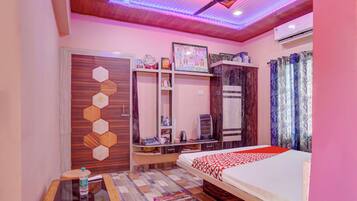 Une chambre à coucher comprenant un lit, un bureau, une armoire et un ventilateur de plafond.