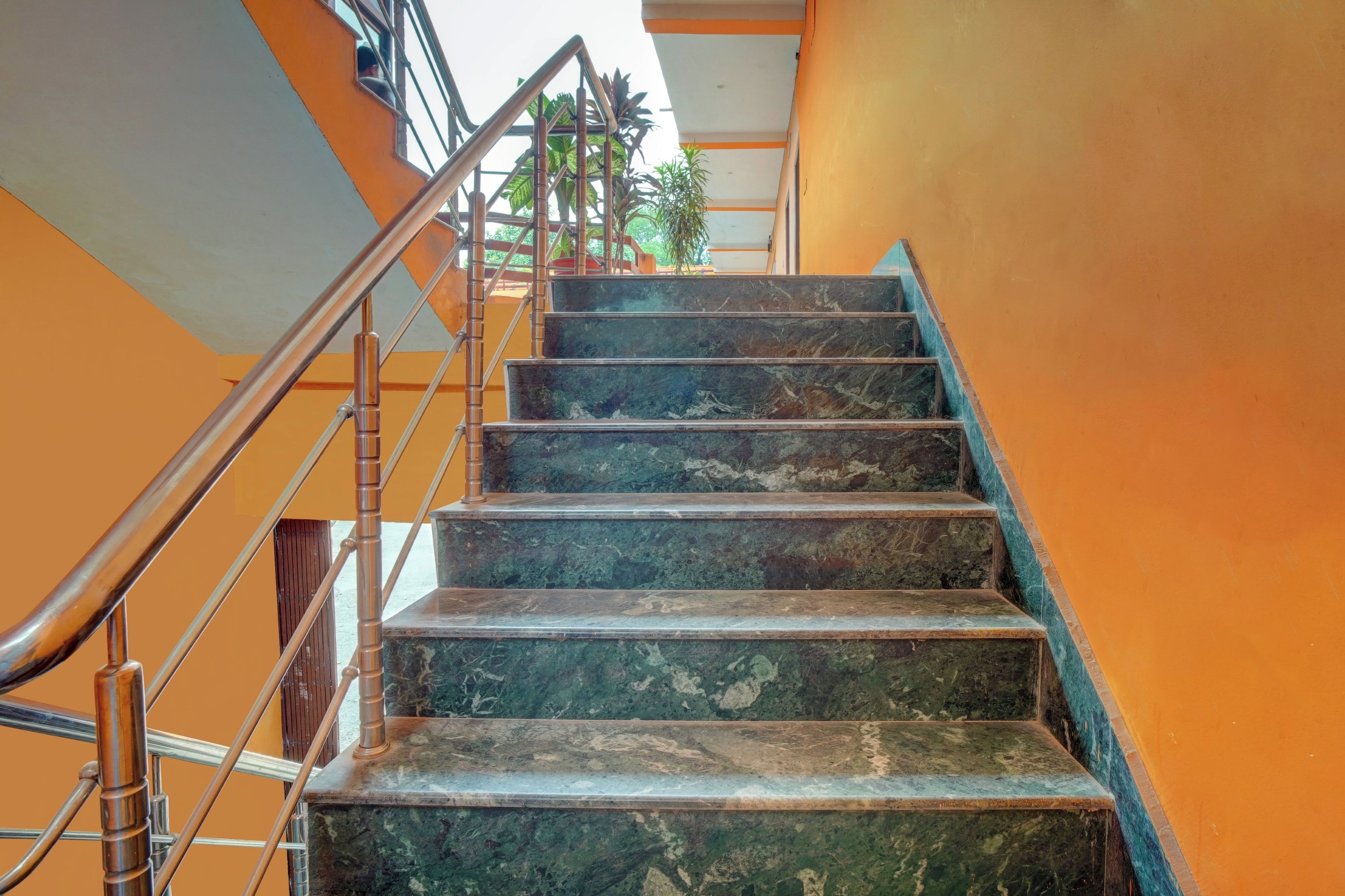 Una escalera con barandillas de metal y peldaños de mármol.