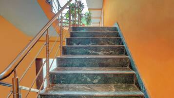Una escalera con barandillas de metal y peldaños de mármol.