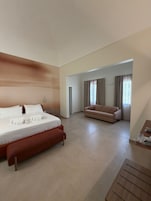 Una habitación de hotel con cama, sofá y una mesita.
