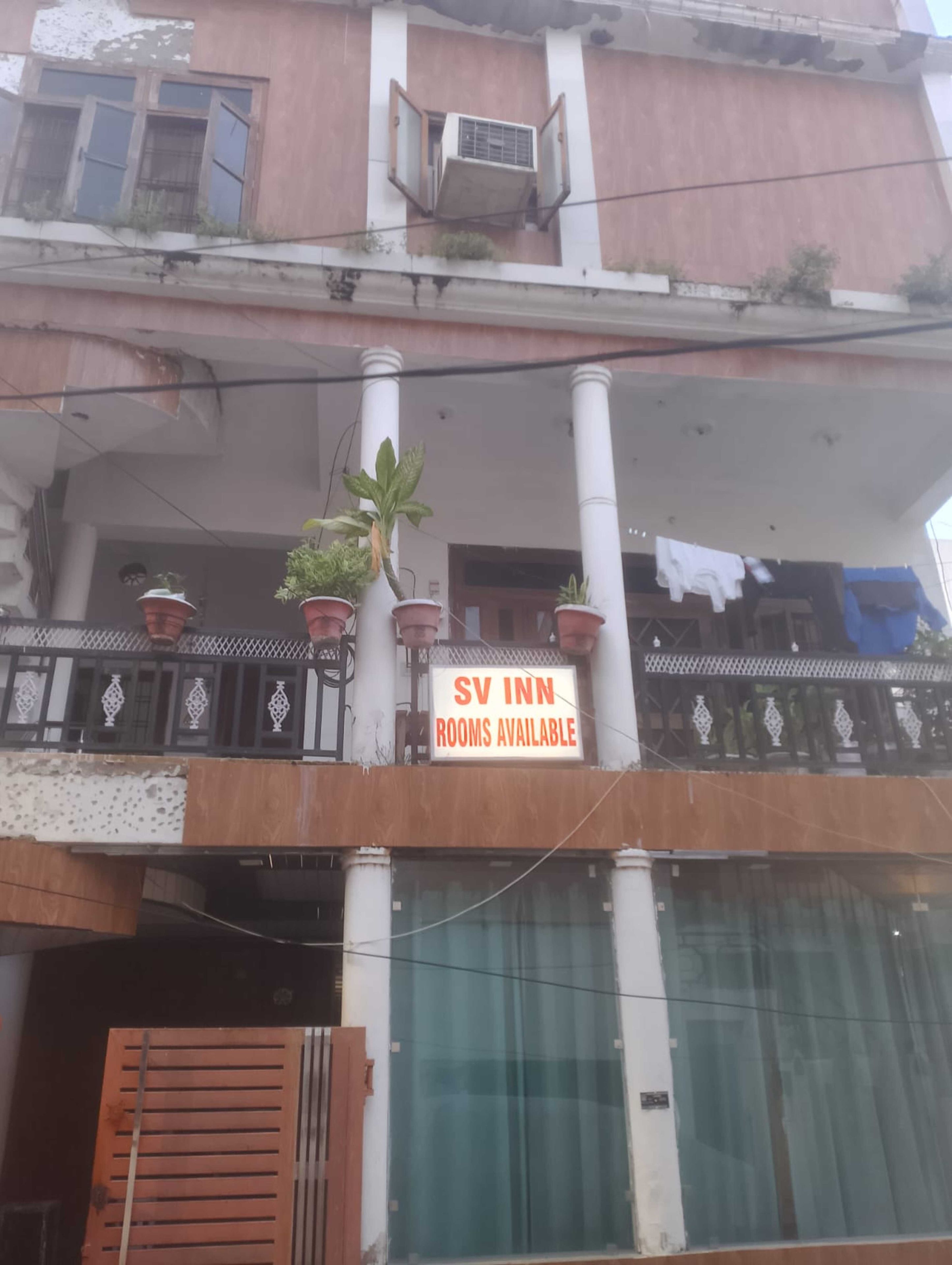 Un edificio con un cartel que indica 'SV INN ROOMS AVAILABLE'.