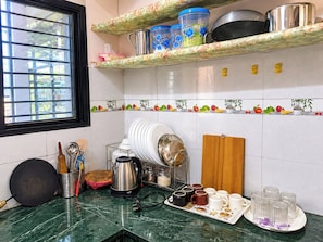 Eine Küche mit Fenster, einem Herd, einer Kaffeemaschine und verschiedenen Küchengeräten.
