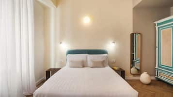 Un dormitorio con cama, mesitas de noche, un espejo y un armario.