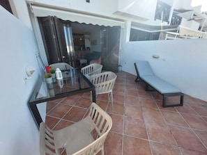 A patio with a glass table, white plastic chairs, a bench, and a tiled floor. - 3 in Paradise (Adeje)