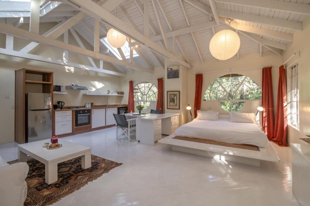 Un dormitorio moderno con una cama grande, un escritorio y una kitchenette.