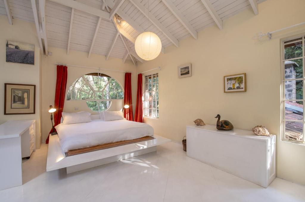 Une chambre à coucher avec un lit, un bureau et une fenêtre avec des rideaux.