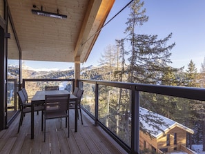 A wooden deck with a table and chairs, overlooking a mountainous landscape with trees and a cabin. - Superior Chalet # 5 With Sauna & Hot Tub (Stadl-Predlitz)