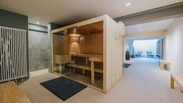 A modern interior with a sauna, a wooden bench, and a glass partition.