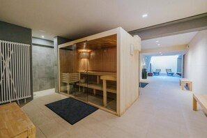 A modern interior with a sauna, a wooden bench, and a glass partition.