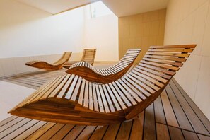 Une rangée de bancs en bois, dotés d’un dossier et d’une assise à lattes, disposés en ligne droite sur une terrasse en bois.