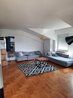 A modern living room with a sofa, a coffee table, and a patterned rug. - Cozy 1-bedroom apartment in tranquil Skopje with AC and free parking (Skopje)