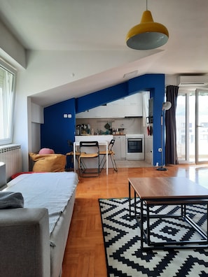 A compact living space with a kitchenette, a dining area, and a bedroom. - Cozy 1-bedroom apartment in tranquil Skopje with AC and free parking (Skopje)
