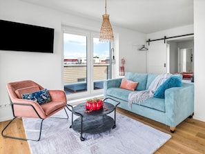 A modern living room with a sofa, chair, and a coffee table. - Apartment in Olpenitz With Swimming Pool (Kappeln)