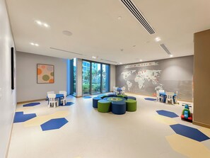 A modern children's play area with seating and a world map mural. - Spacious Modern 3BR apartment in Dubai Marina, Sea View, Dubai Eye View (Dubai)
