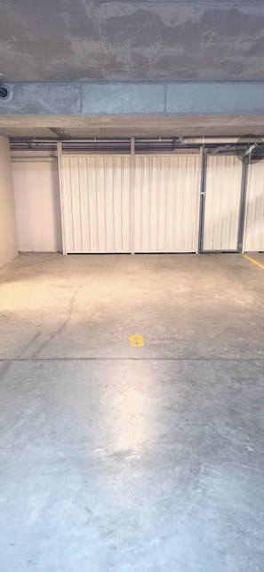 Eine Tiefgarage mit Betonböden und Metall-Garagentoren.