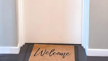 Une porte blanche portant le numéro « 9 » et surmontée d’un élément décoratif.