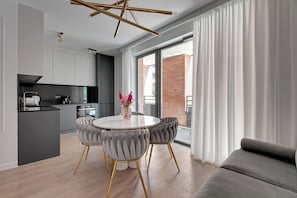 Eine moderne Küche mit Essbereich, inklusive rundem Tisch, Stühlen und einem Blumenstrauß.