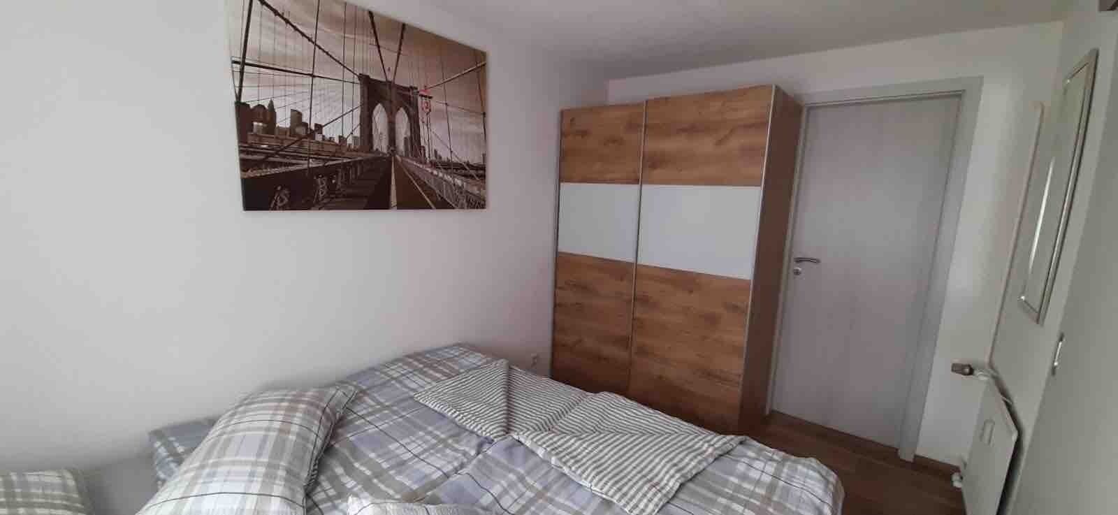 Ein Schlafzimmer mit einem Bett, einem Kleiderschrank und einem Bild an der Wand.