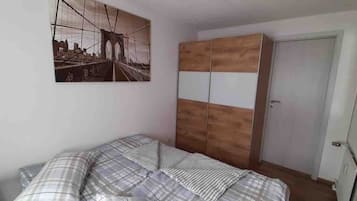 Ein Schlafzimmer mit einem Bett, einem Kleiderschrank und einem Bild an der Wand.