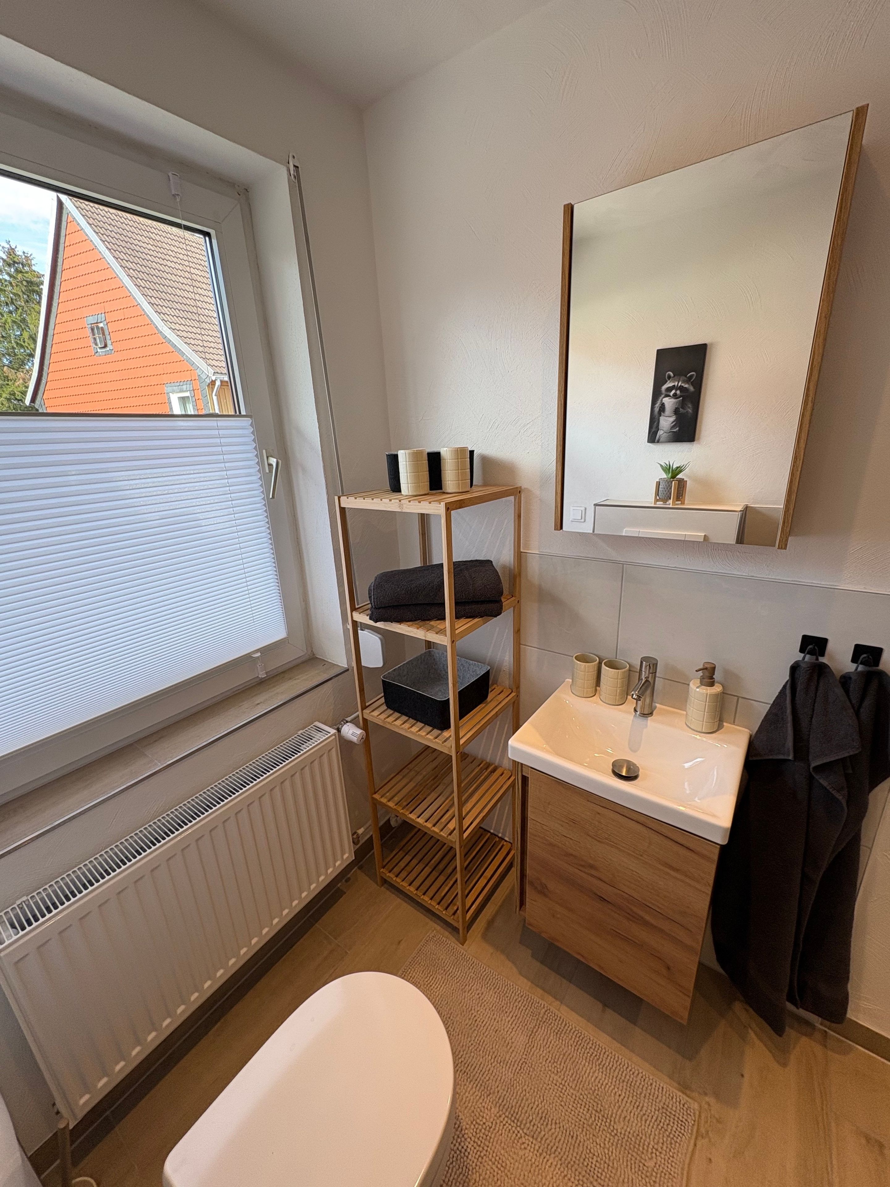 Ein modernes Badezimmer mit Toilette, Waschbecken und einer Holzauslage.