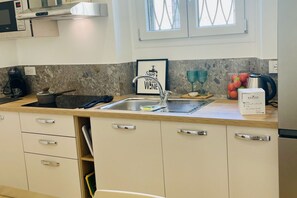 A kitchen with a stainless steel sink, a coffee maker, and a framed inspirational quote on the wall. - BNBOOK – Residenza Cavallotti 1 (Monza)