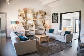 Ein stilvolles Wohnzimmer mit einer Couch, einem Couchtisch und einer außergewöhnlichen Holzregaleinheit.