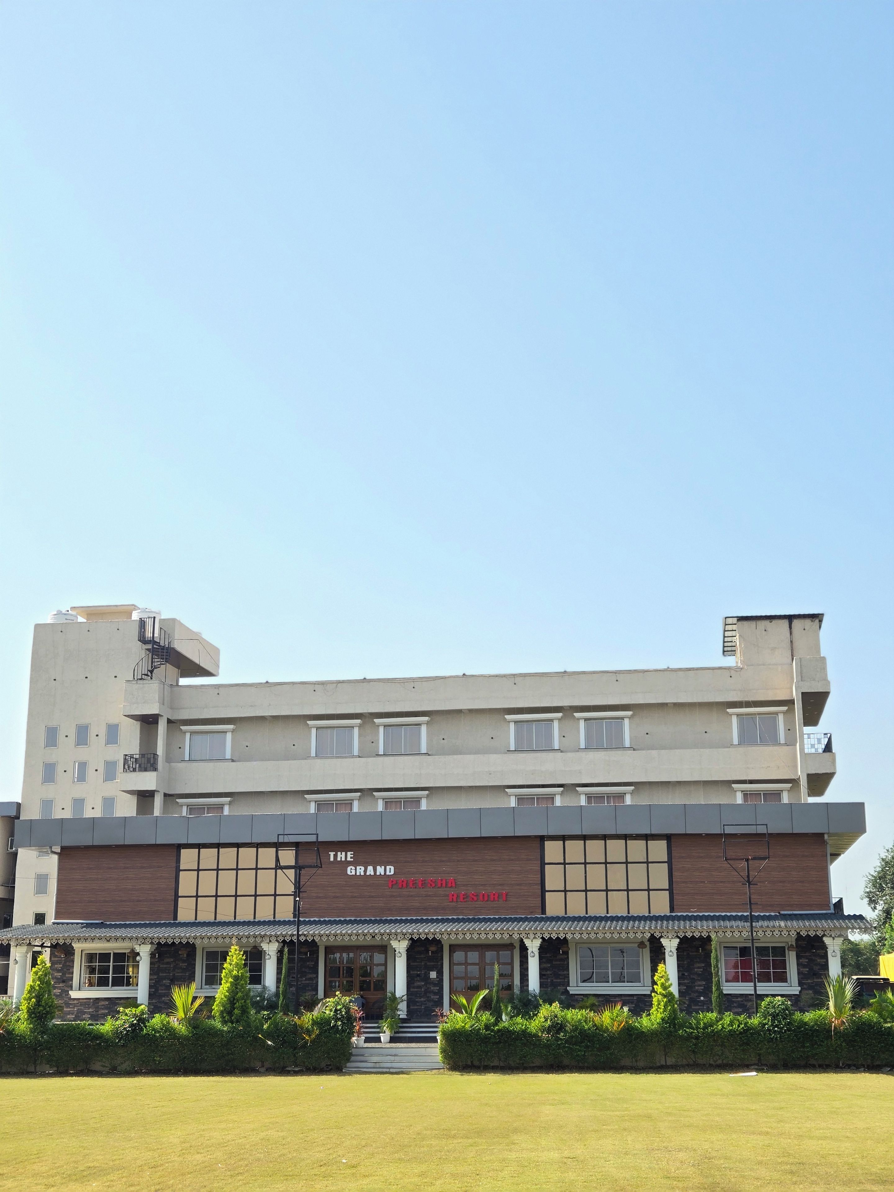 Un edificio de varios pisos con un cartel que dice 'The Grand Pheesha Resort'.