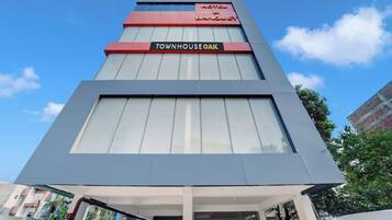 Un hotel moderno con un letrero llamativo que dice 'TOWNHOUSE OAK HOTEL & BANQUET'.