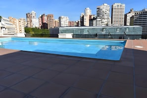 Une piscine sur le toit offrant une vue sur la ville.