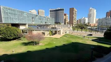 A cityscape with modern buildings, a grassy area, and a clear sky.