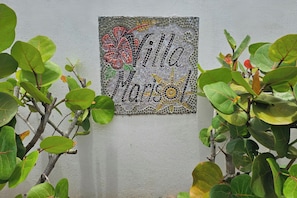 A wall with a mosaic sign that reads 'Villa Maria'.