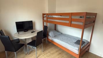 Ein Zimmer mit einem Etagenbett, einem Schreibtisch mit Computer und zwei Stühlen.
