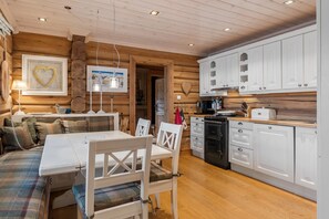 Ein gemütliches Blockhaus-Interieur mit Essbereich, Küche und Kamin.