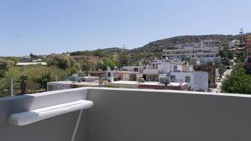 Zona residencial con varios edificios, algunos con techos planos y otros con techos inclinados, bajo un cielo despejado.