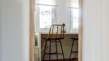 Una habitación con un espejo grande que refleja una silla y un ventanal.