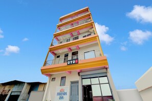 Un edificio de hotel de varios pisos con balcones y un cartel que dice 'Hotel Friends Inn'.