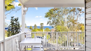 Elevated balcony viewpoint looking across outdoor railings toward surrounding trees and coastal scenery.    - 1912 Heritage House | Kiama Coastal Living (Kiama)