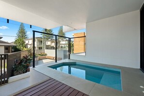 Ein moderner Poolbereich mit Wohnbebauung im Blick.
