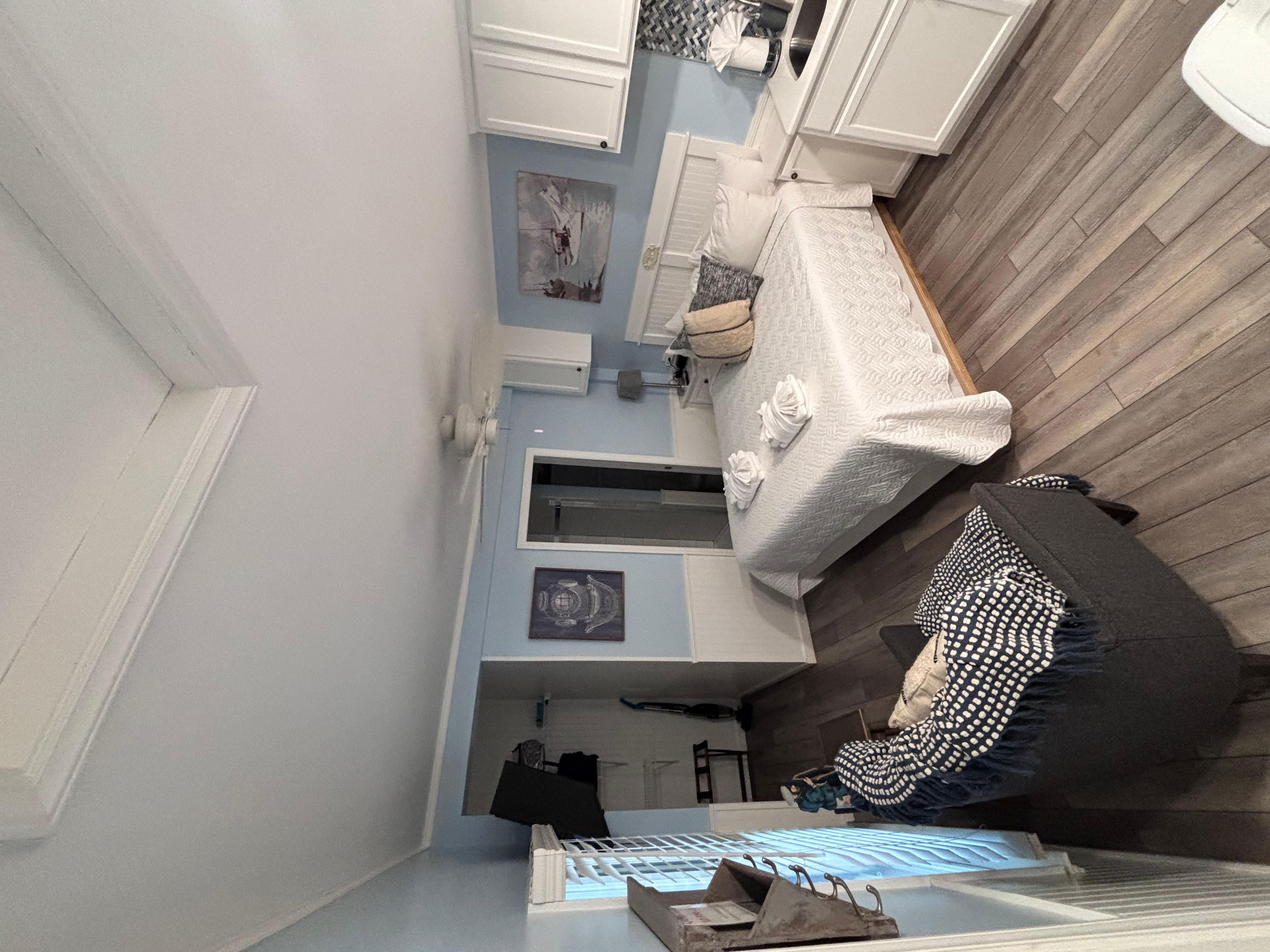 A room with a bed, a dresser, a mirror, and a window.